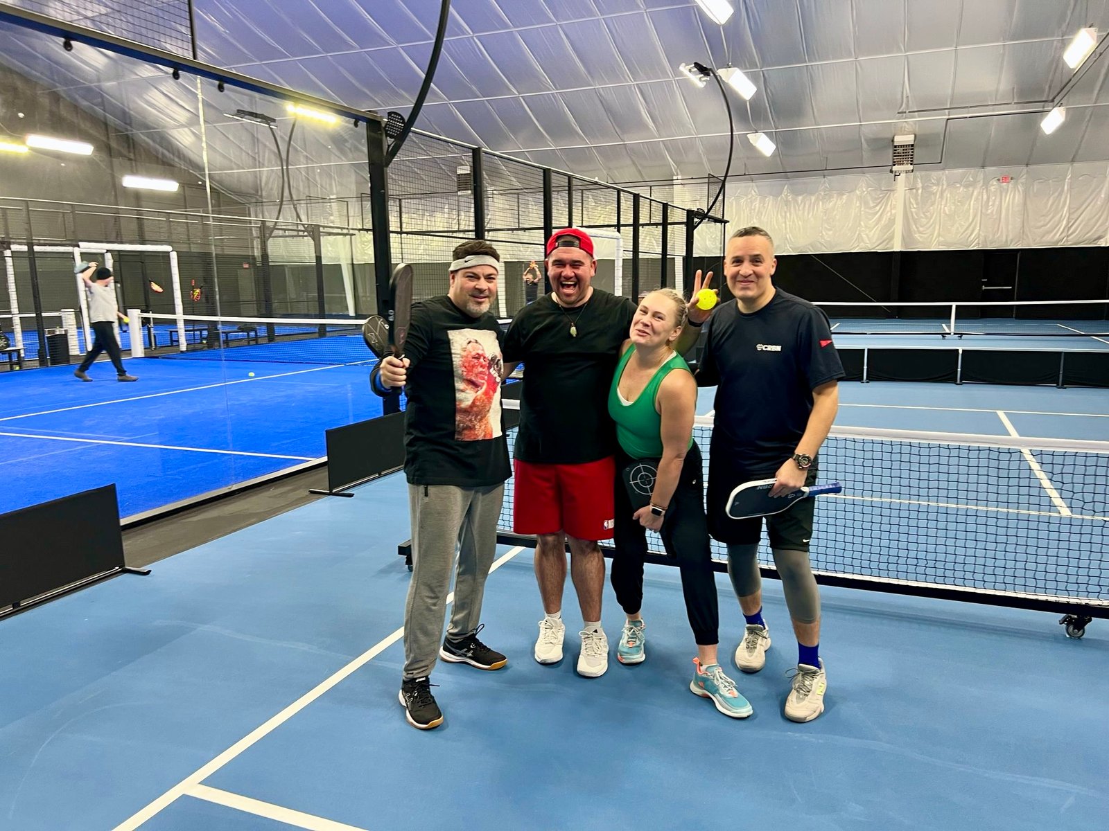 Group of four people on blue padel court