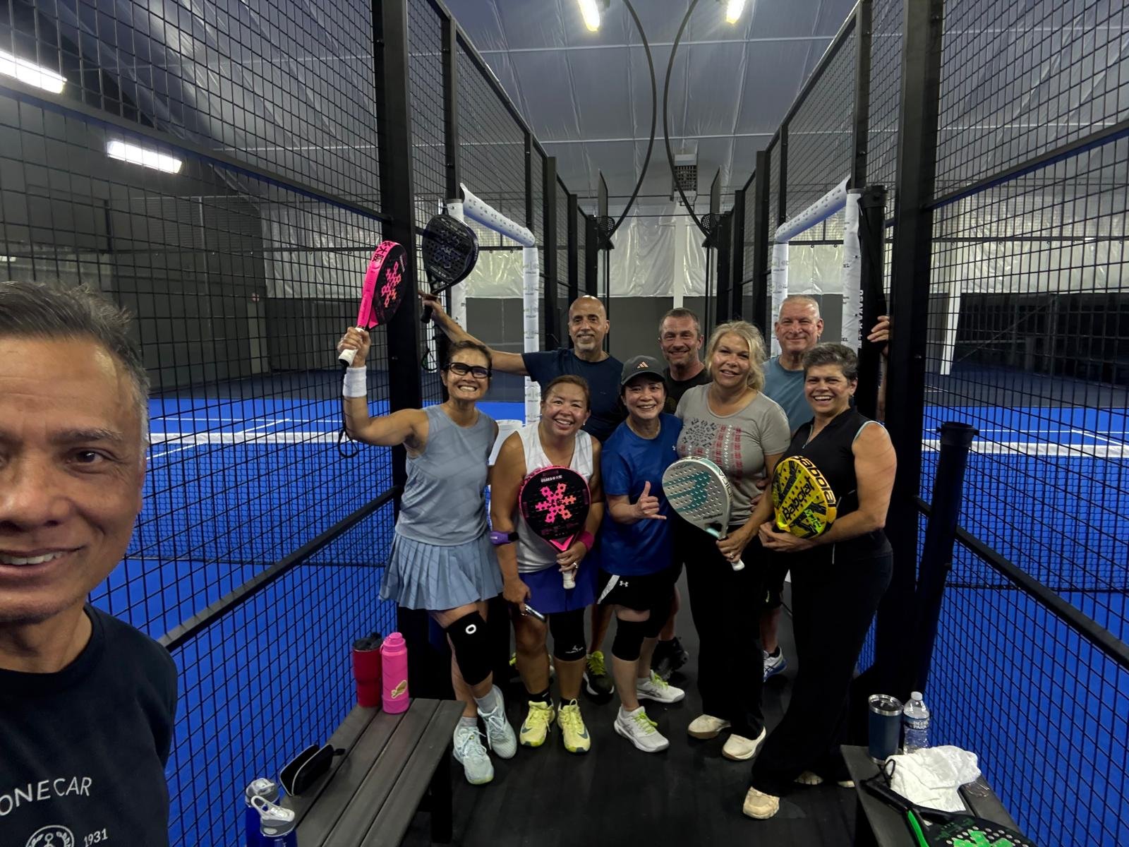 Group of people on padel court holding rackets