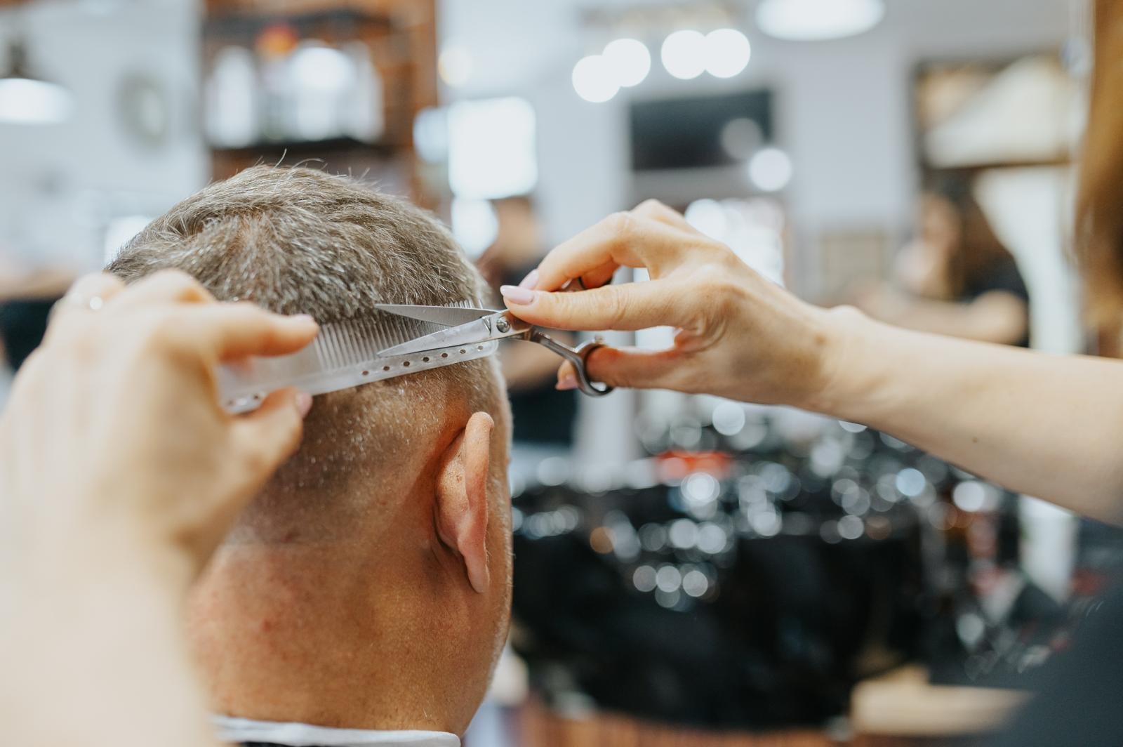 Barber using clippers on client