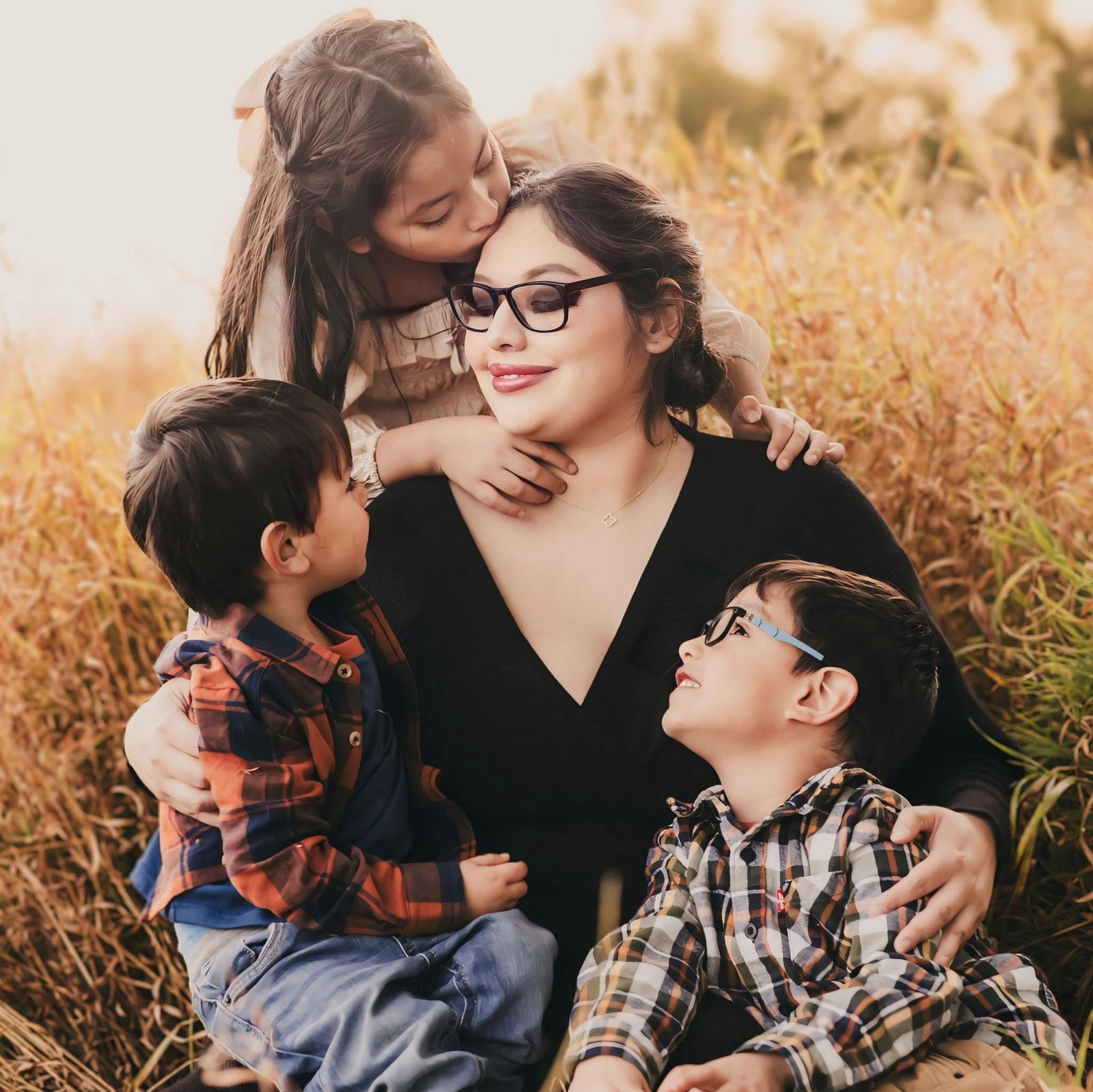 The Carrizales family smiling together outdoors in a sunlit field