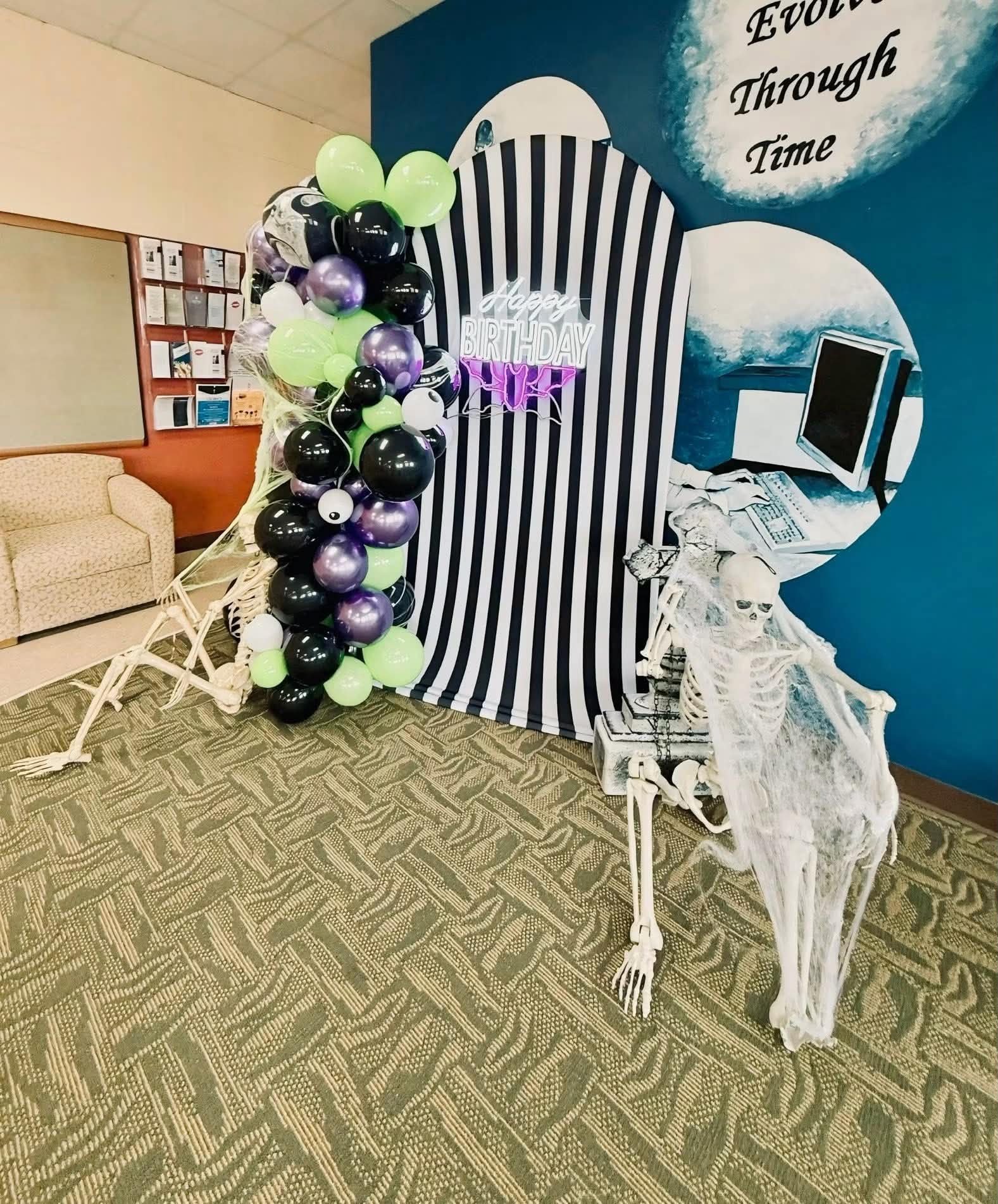 Black, green and purple Beetlejuice-themed balloon column with striped backdrop