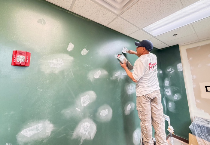 Professional painter patching and repairing a wall before interior painting