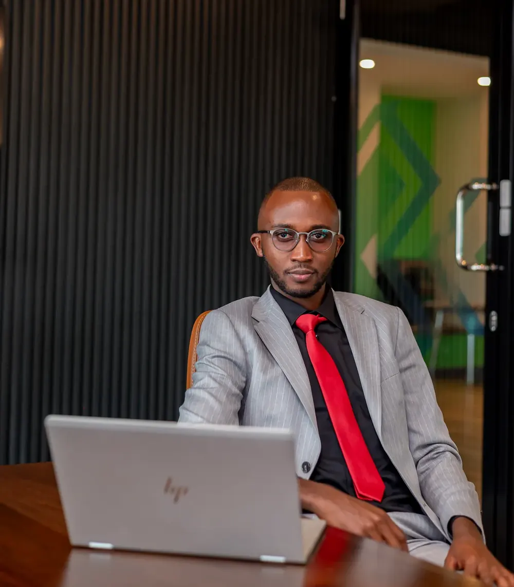 Elvis Warutumo in a grey suit and red tie.