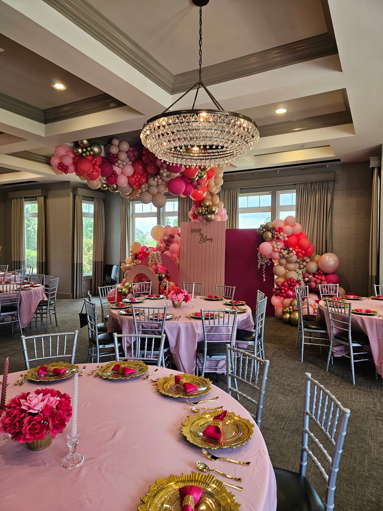 Elegant banquet hall decorated with a red, pink, and gold organic balloon garland by Joiful Expressions