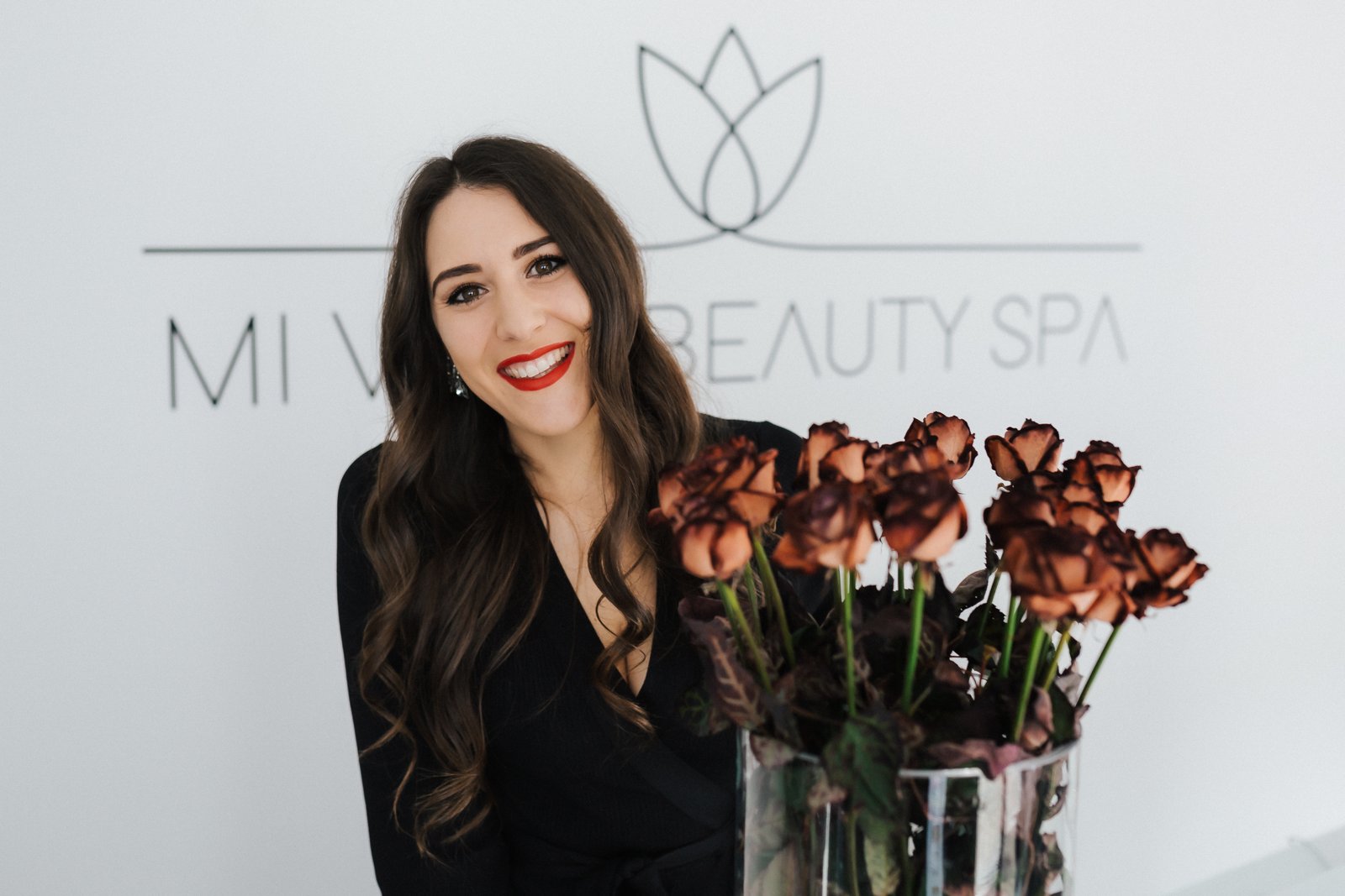 Inhaberin des Mi Vida Beauty Spa mit einem Blumenstrauß