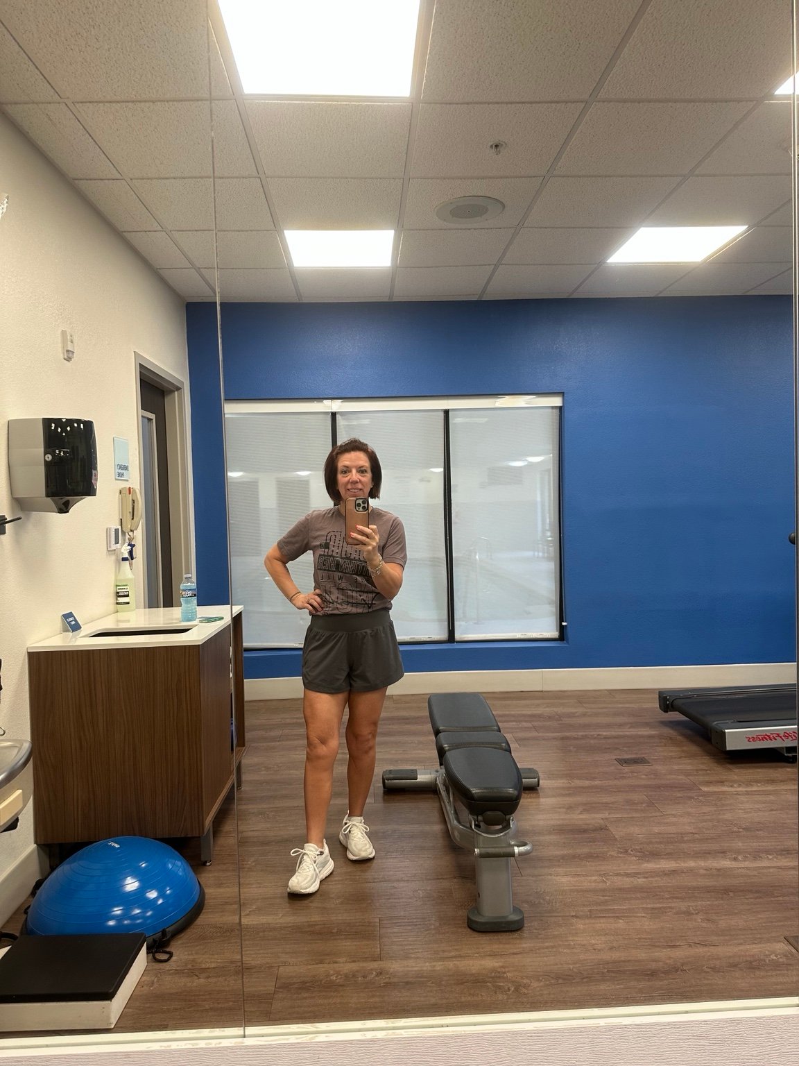 Jennifer Urias standing in a gym in a gray T-shirt and shorts