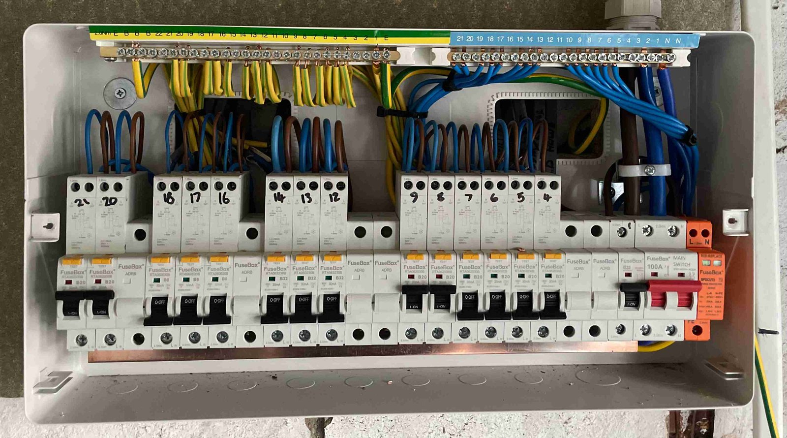Neatly wired consumer unit showing circuit breakers and main switch