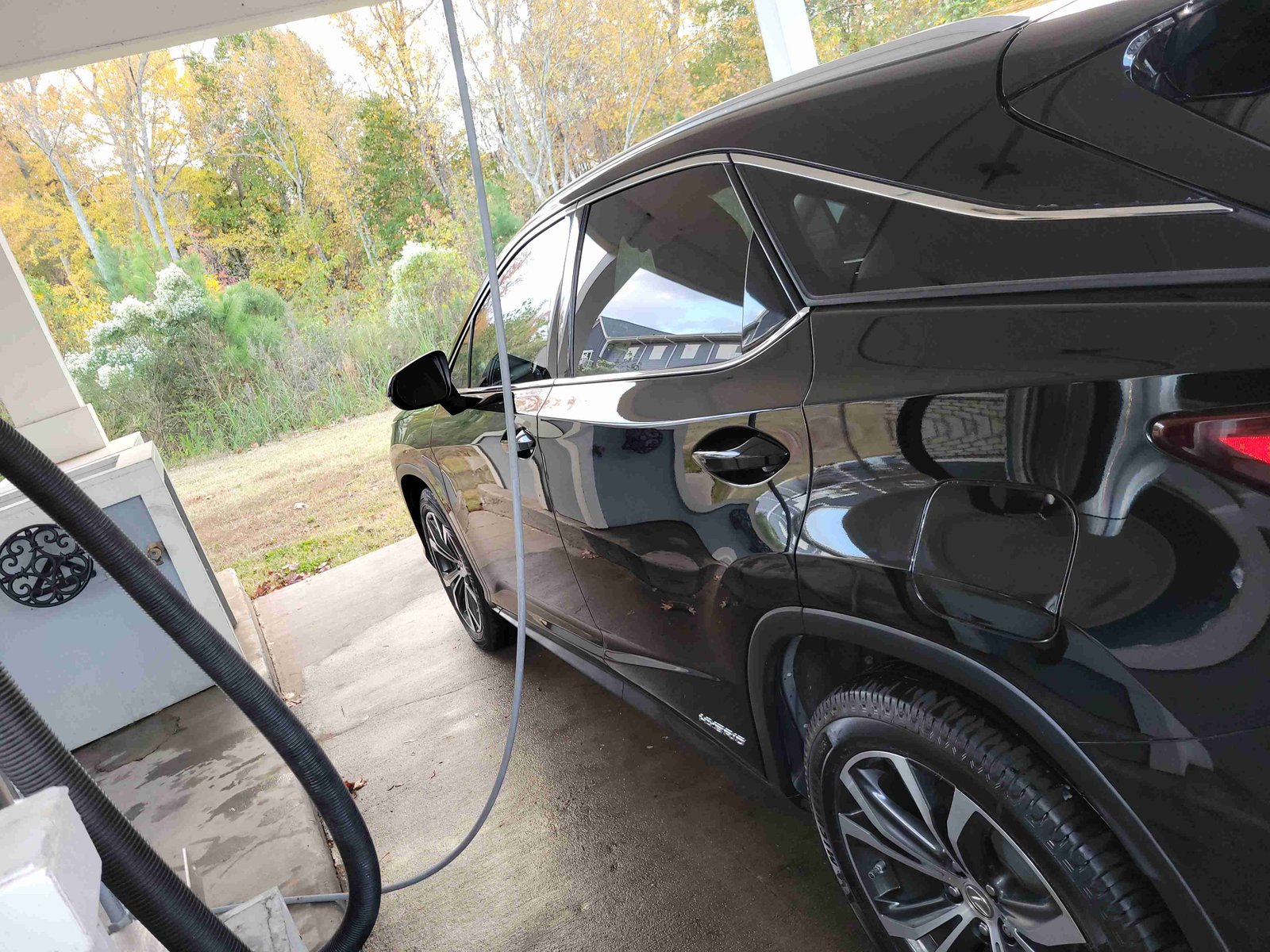 A shiny black SUV in a car wash bay