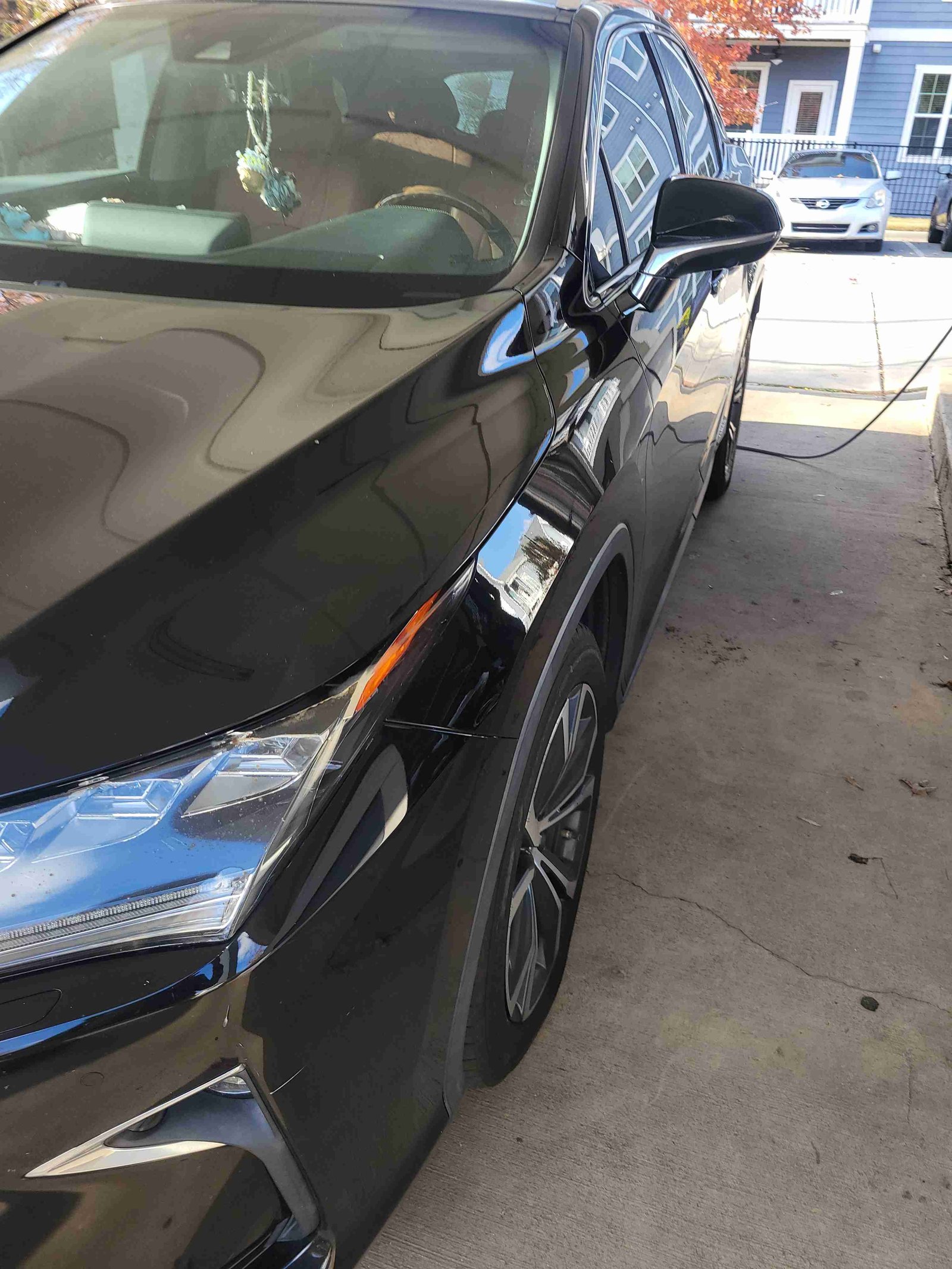 Rear view of a detailed black SUV under a carport