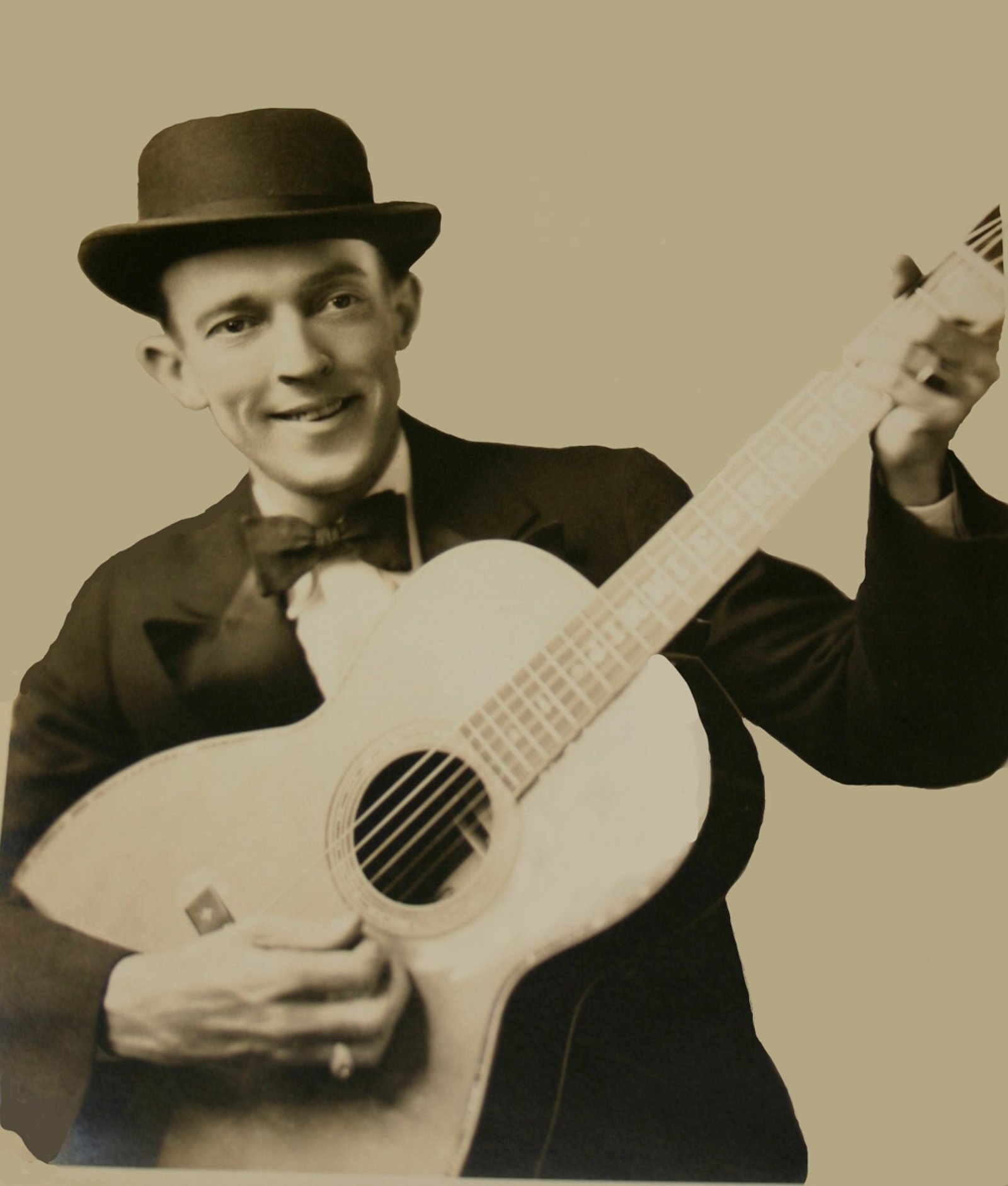 Jimmie Rodgers with guitar, wearing bowler hat and bow tie
