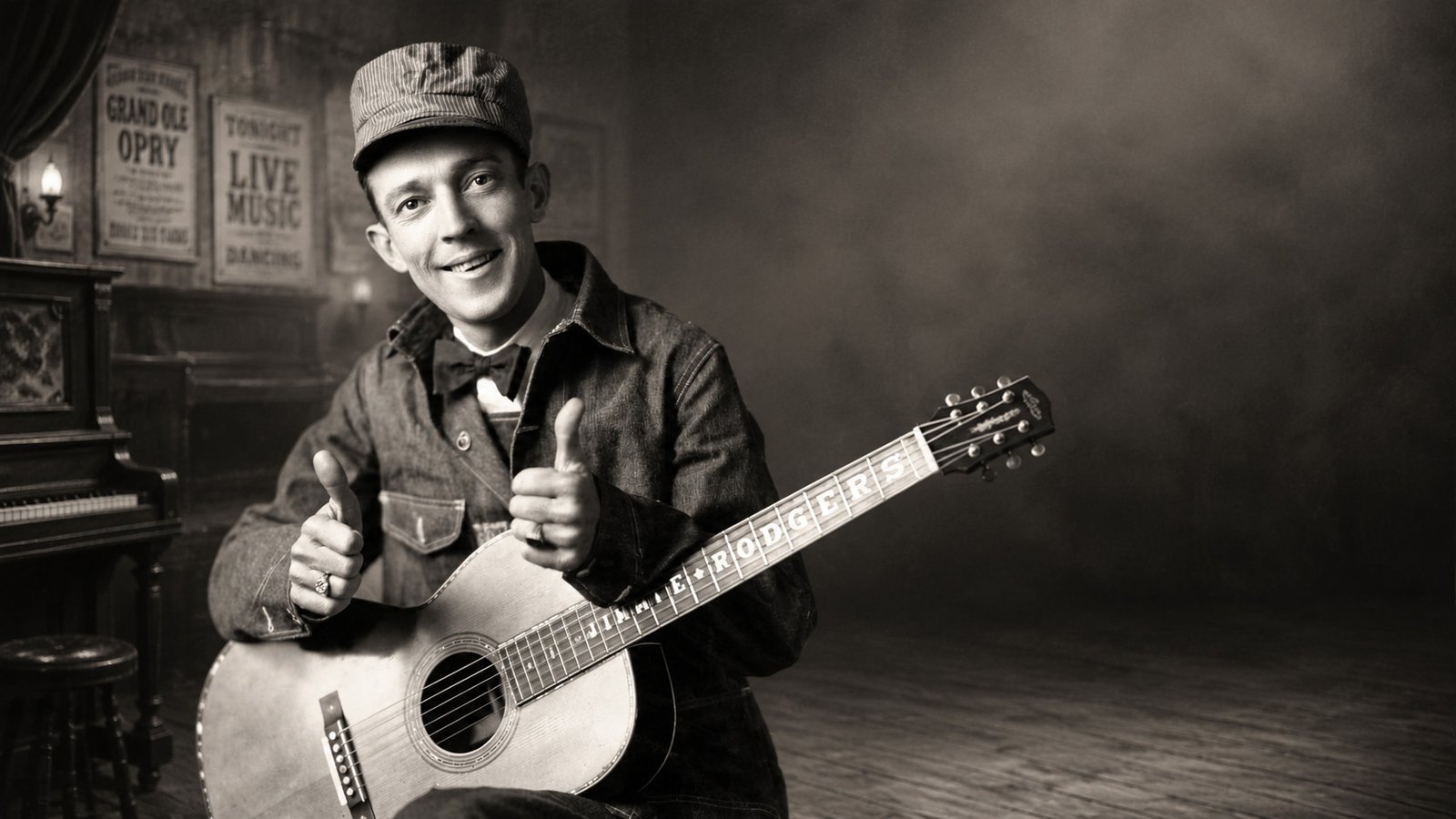 Jimmie Rodgers with guitar in front of Grand Ole Opry sign