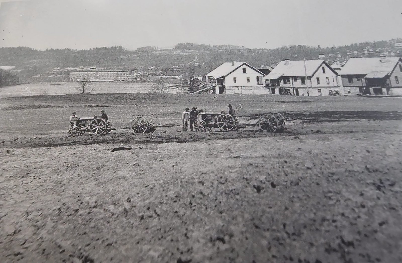 Historic black-and-white photograph of Fries, Virginia, showing houses along the New River, open fields, and people with horse-drawn wagons in the early twentieth century