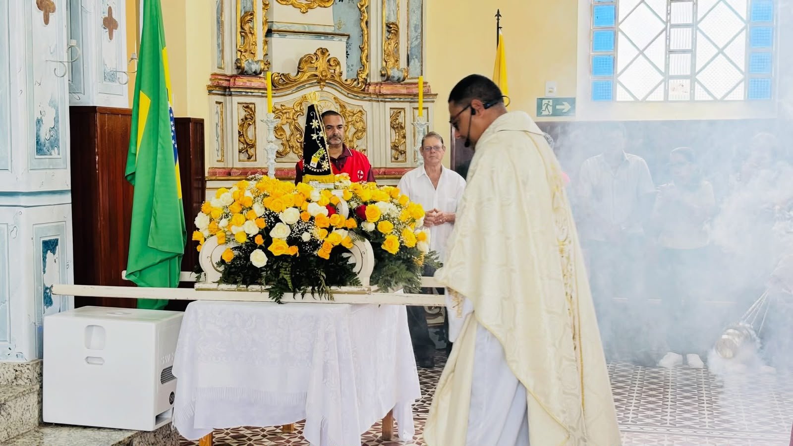 Imagem de Nossa Senhora Aparecida ornamentada com flores durante celebração na Basílica