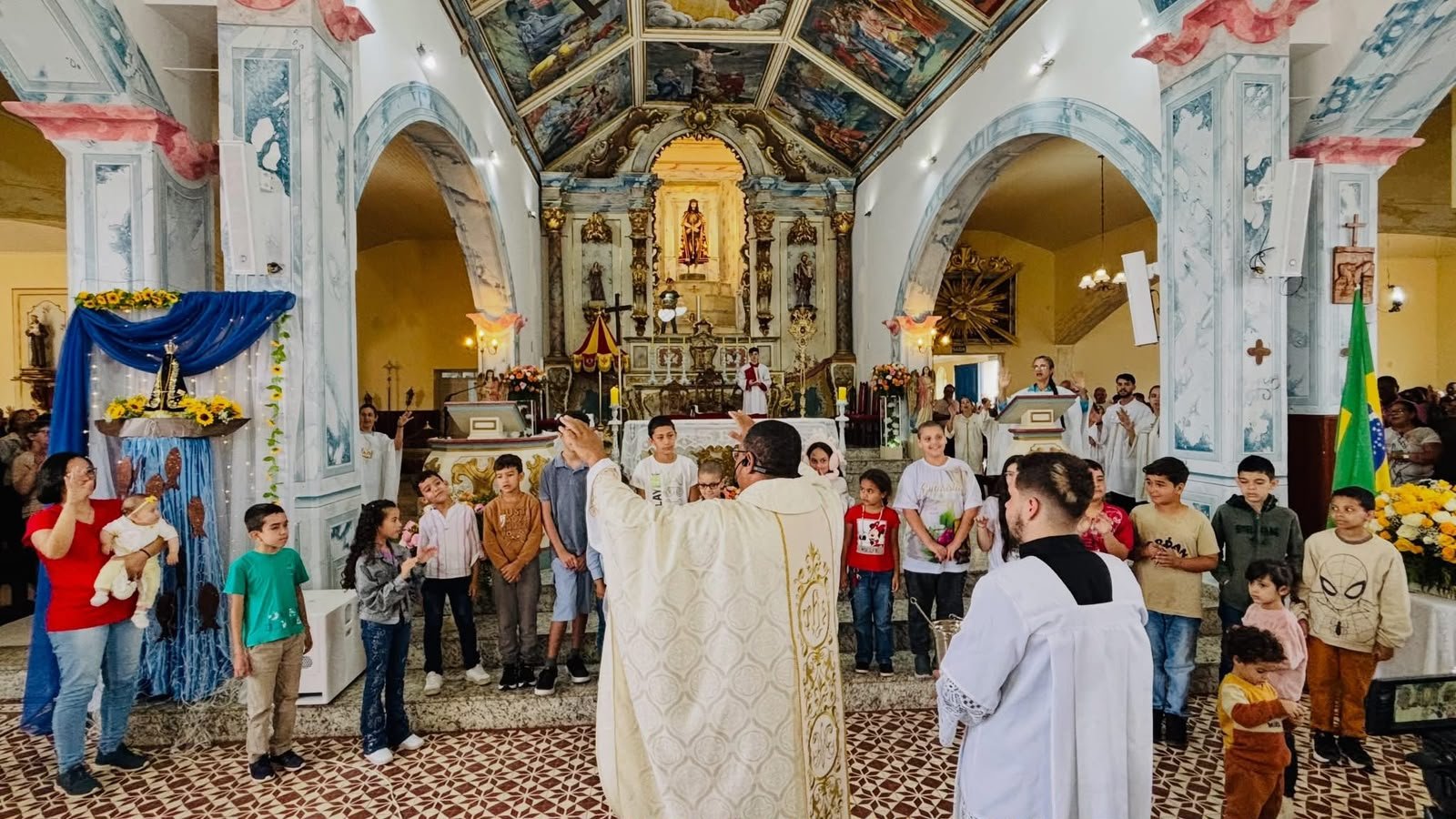 Crianças reunidas diante do altar durante celebração na Basílica