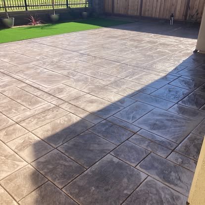 Concrete patio with varied stone pattern and green lawn
