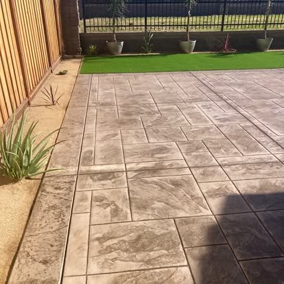 Concrete patio with varied stone design and artificial turf