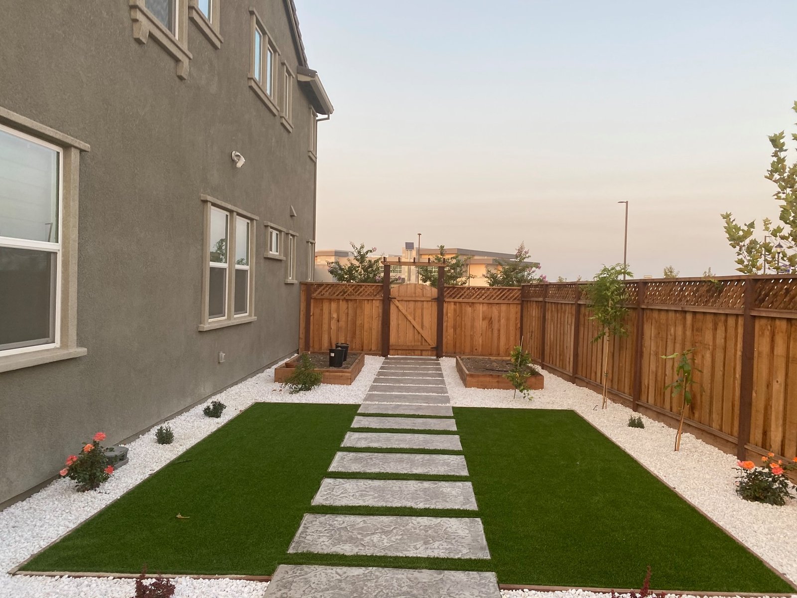 Modern backyard with concrete stepping stones and artificial turf