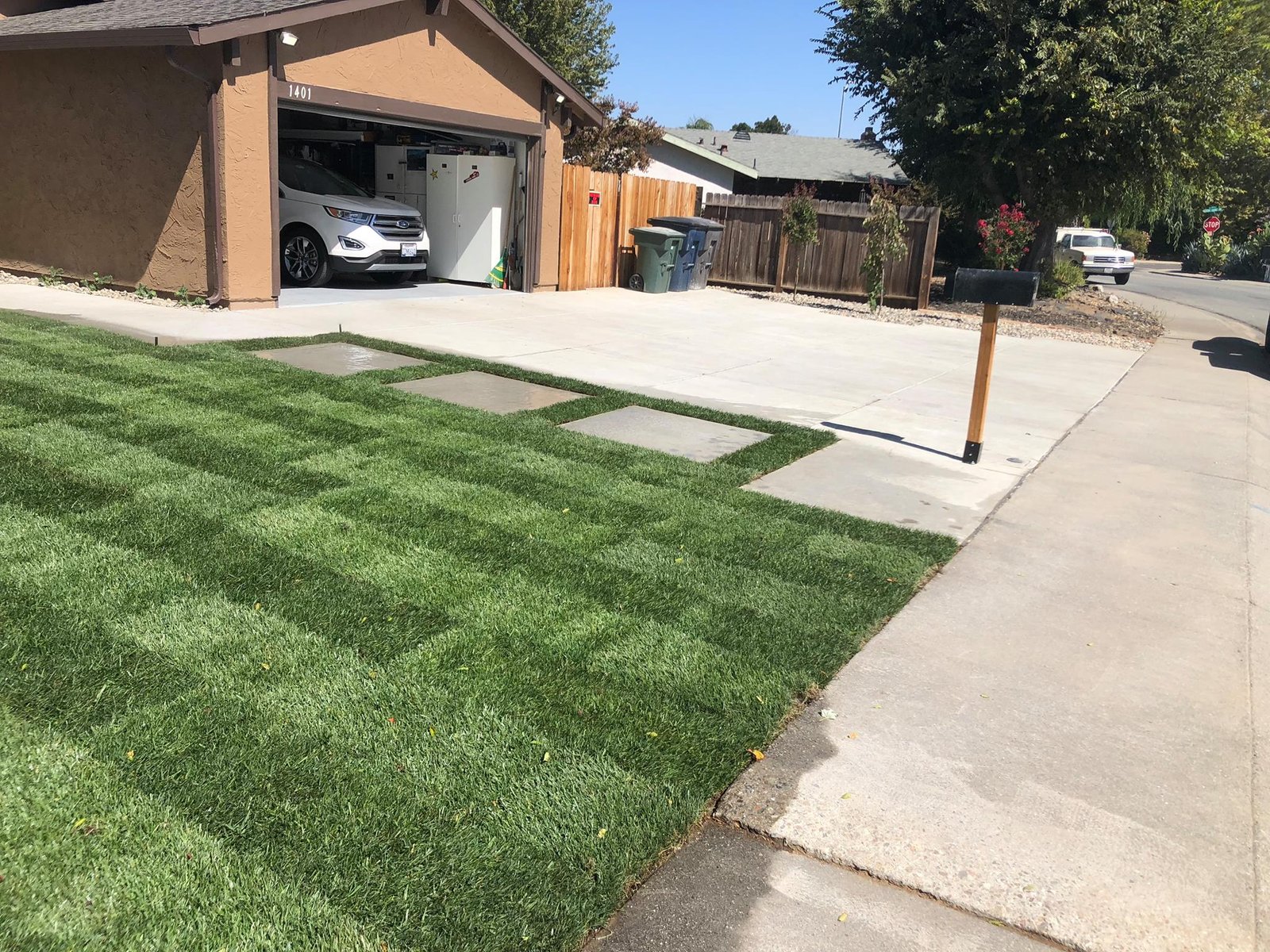 Driveway with concrete and stepping stones leading to garage