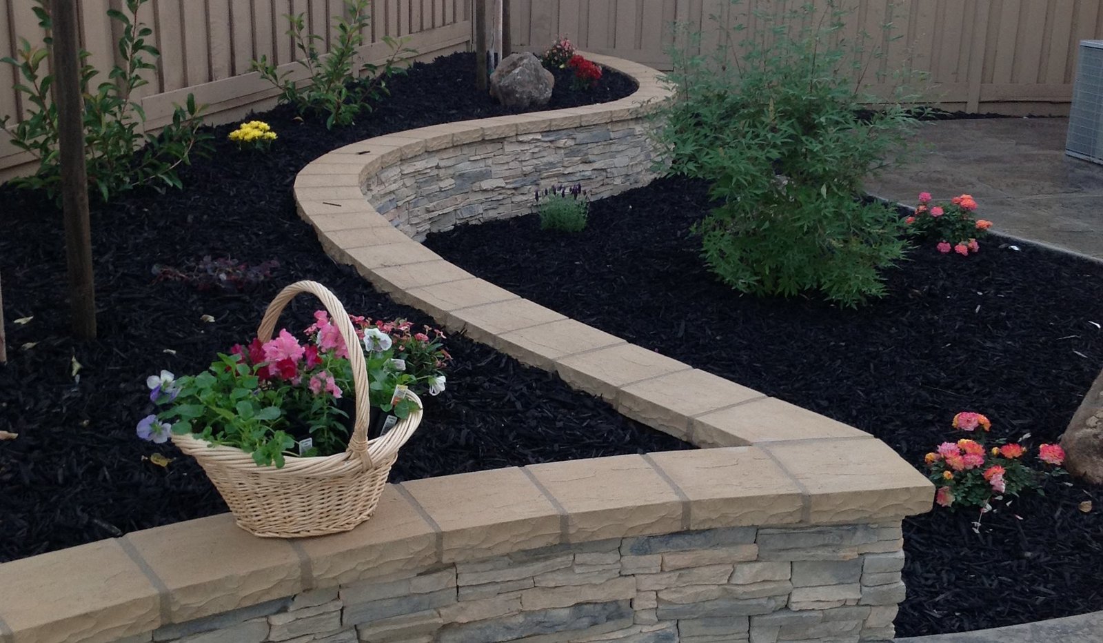 Concrete retaining wall with flower beds and landscaping