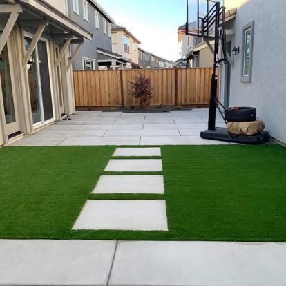 Backyard patio with concrete and artificial turf with stepping stones