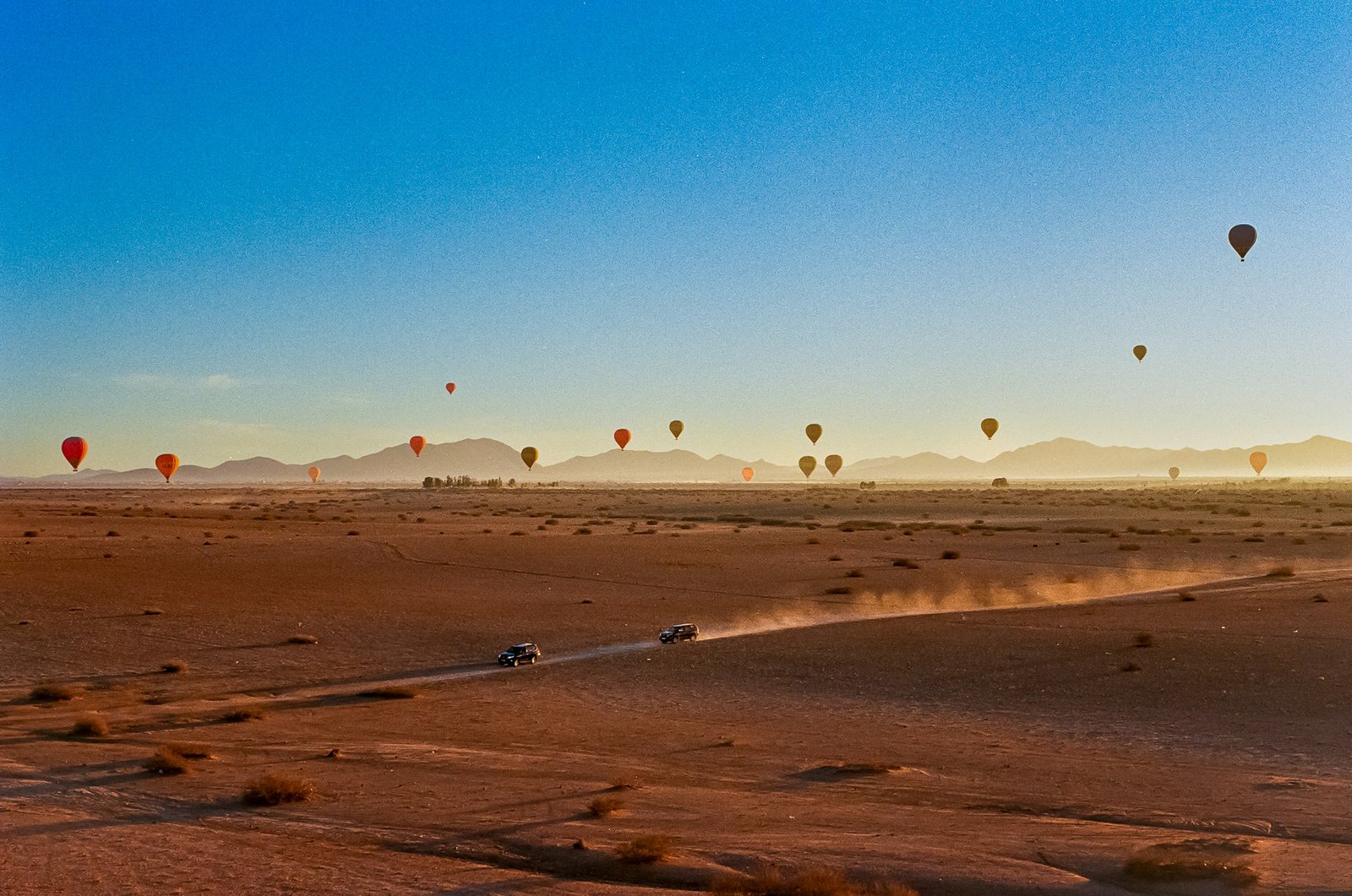 A hot-air balloon rising over the Atlas foothills at dawn, a memorable family experience near Marrakech, Morocco