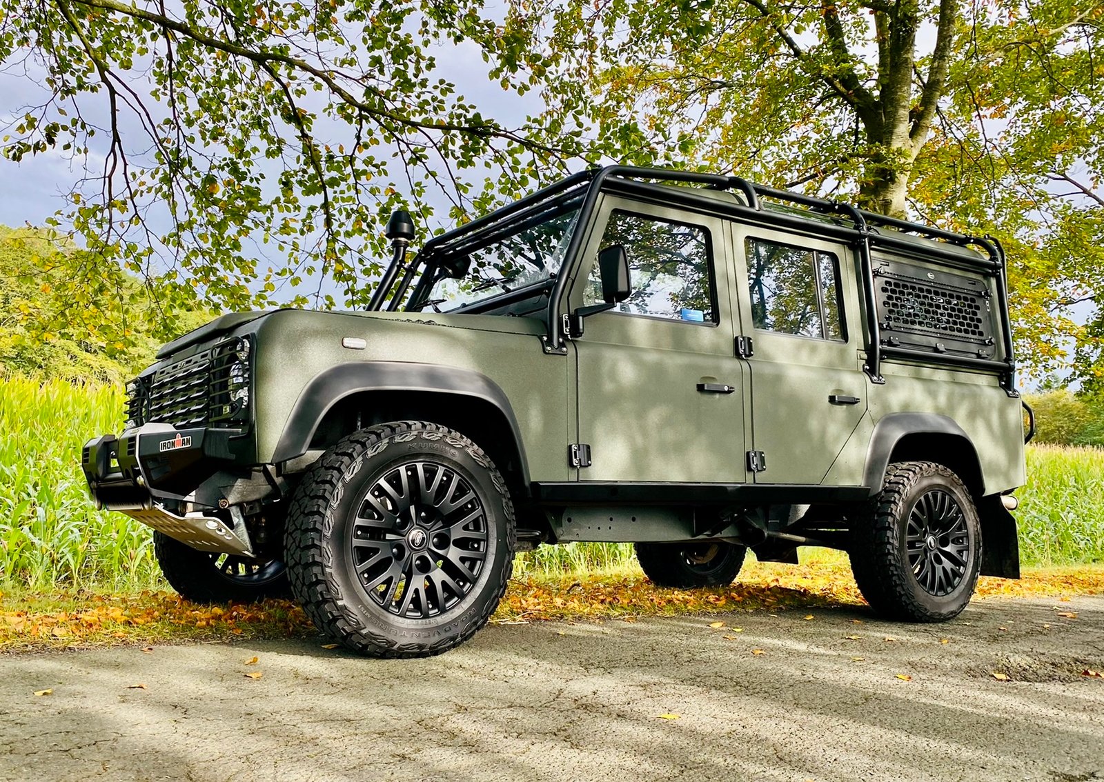 Sander’s green 2004 Land Rover Defender 110 Fit Truck parked outdoors beneath the trees