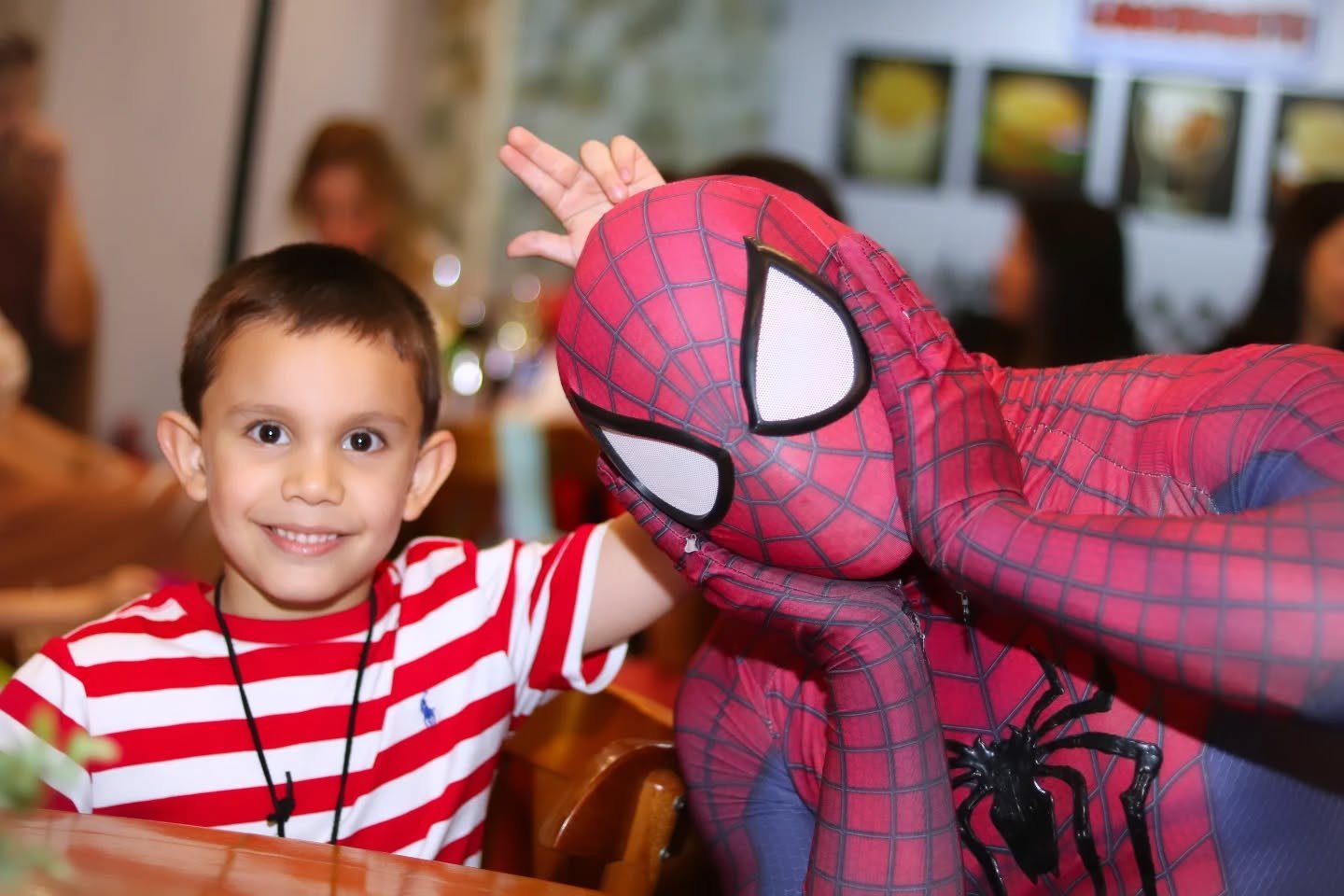 Criança sorrindo com personagem Homem-Aranha