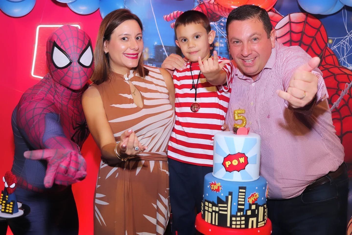 Família com criança e personagem Homem-Aranha em festa temática