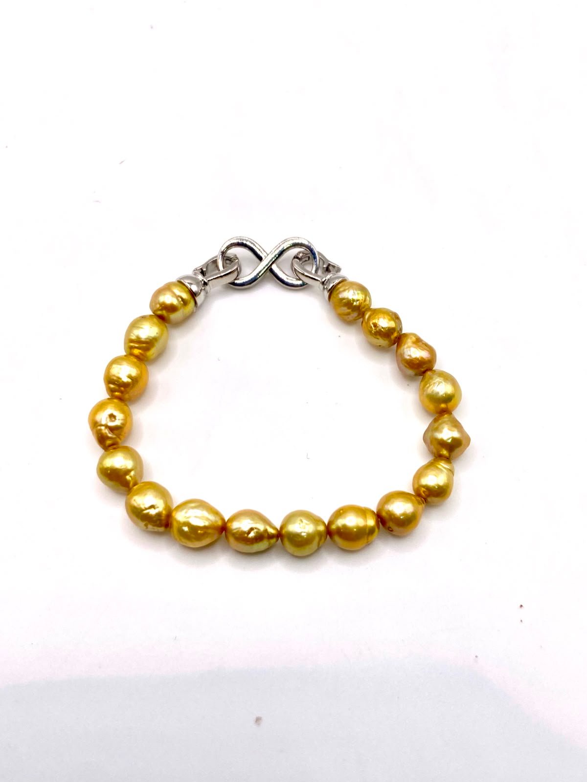 Exquisite gold pearl bracelet featuring lustrous golden pearls with silver infinity clasp, designed for abundance, prosperity, and spiritual connection Gold pearl bracelet by Soluna Gitana - premium gemstone jewelry combining golden pearls with silver clasp for abundance and prosperity