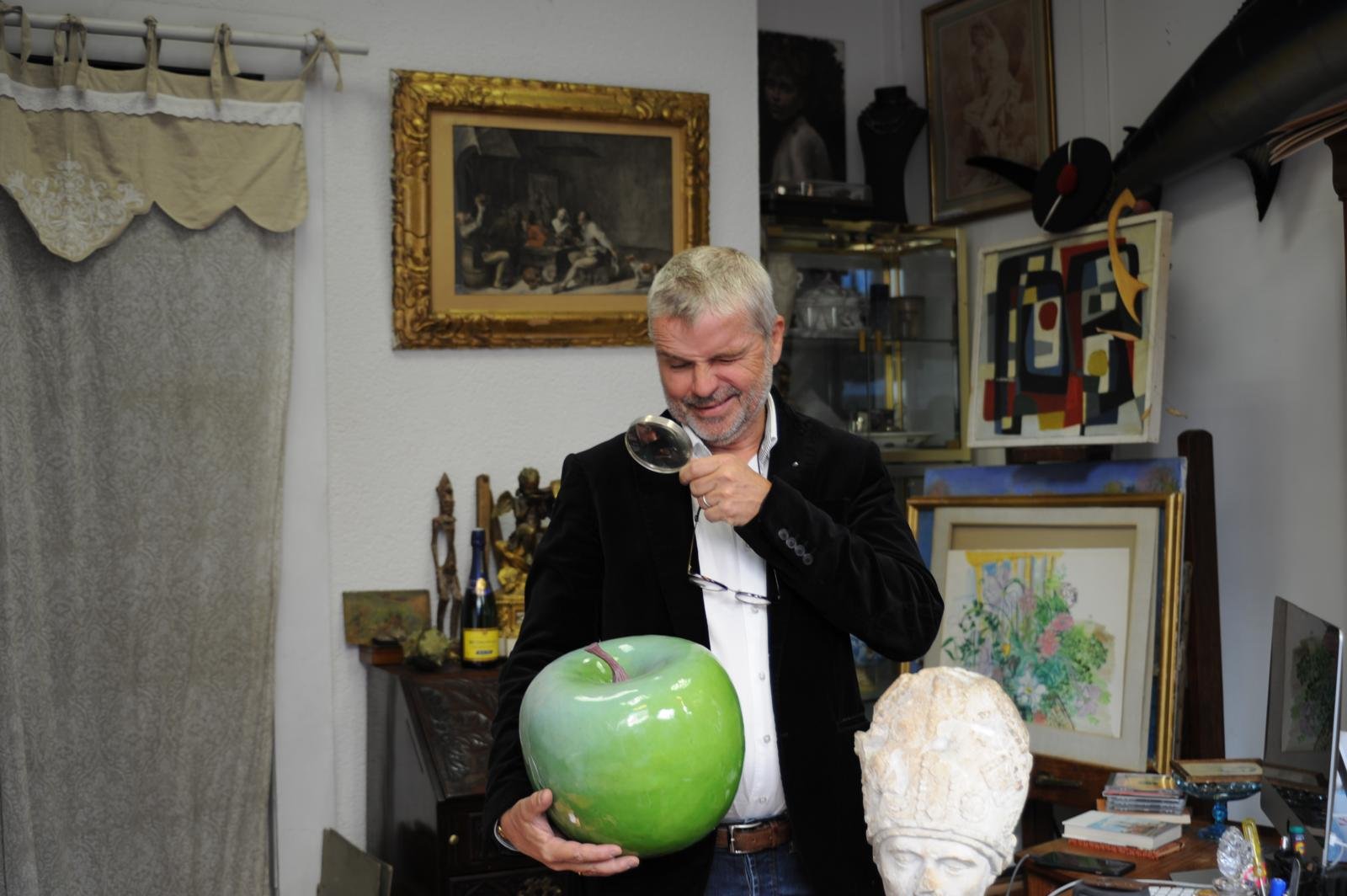 An expert's gloved hands holding an old master drawing up to the light in the gallery study
