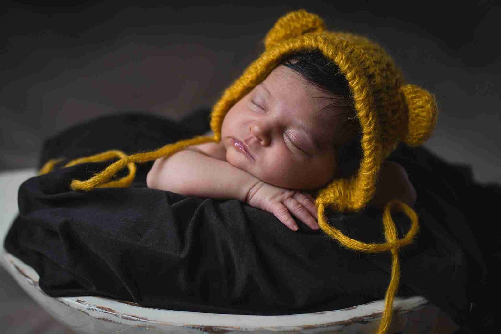 Newborn baby in yellow hat sleeping