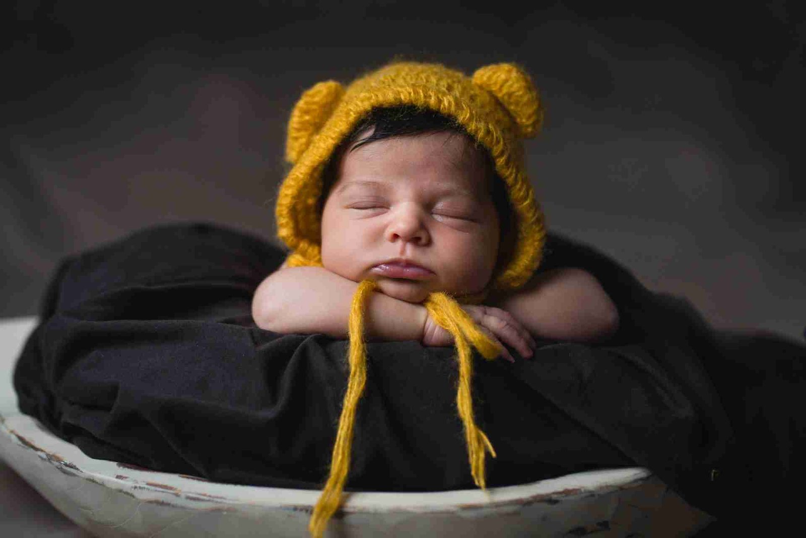 Newborn baby with yellow hat awake