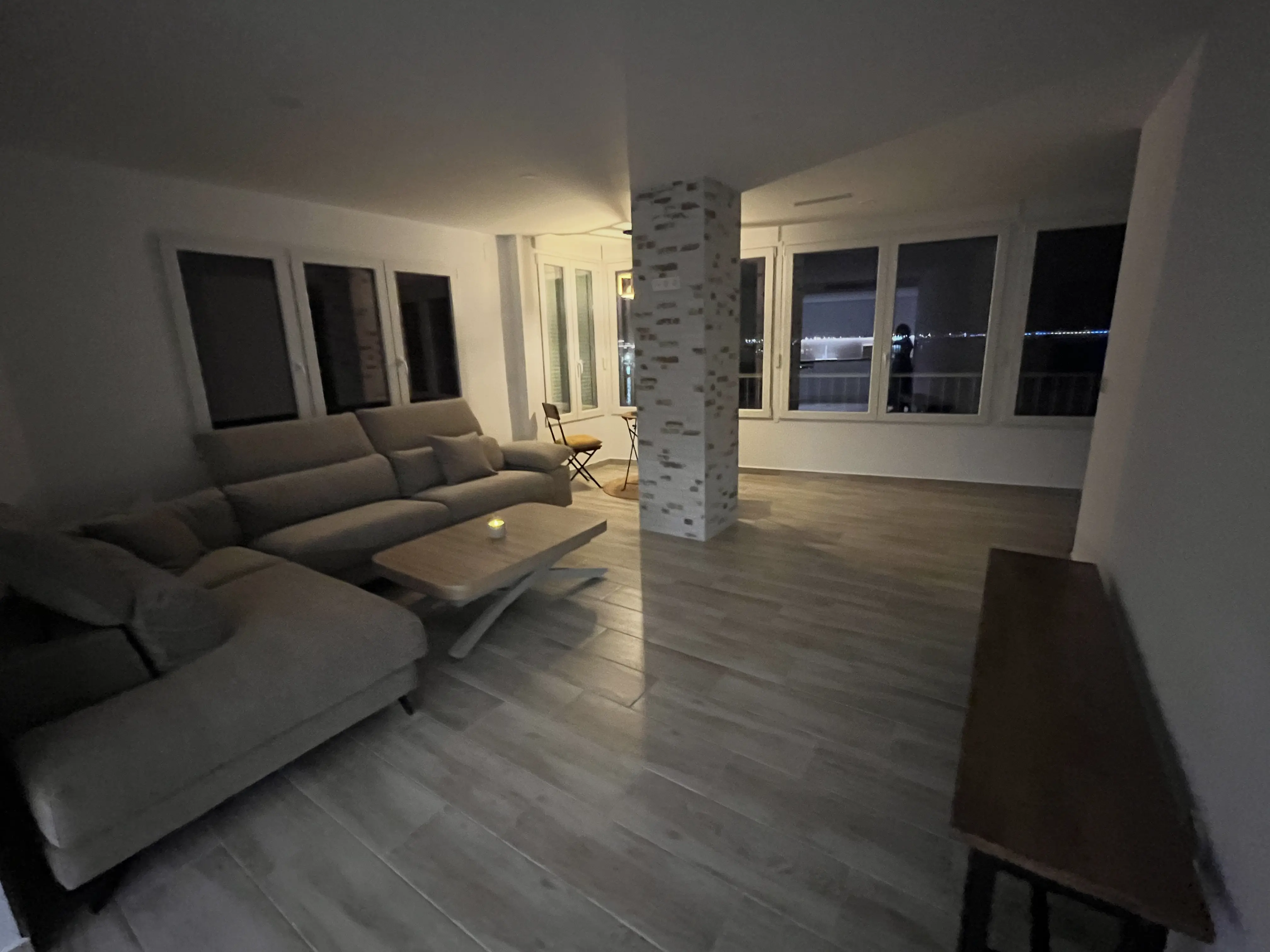 Living room after renovation — bright contemporary space with floor-to-ceiling windows and panoramic Mediterranean sea view