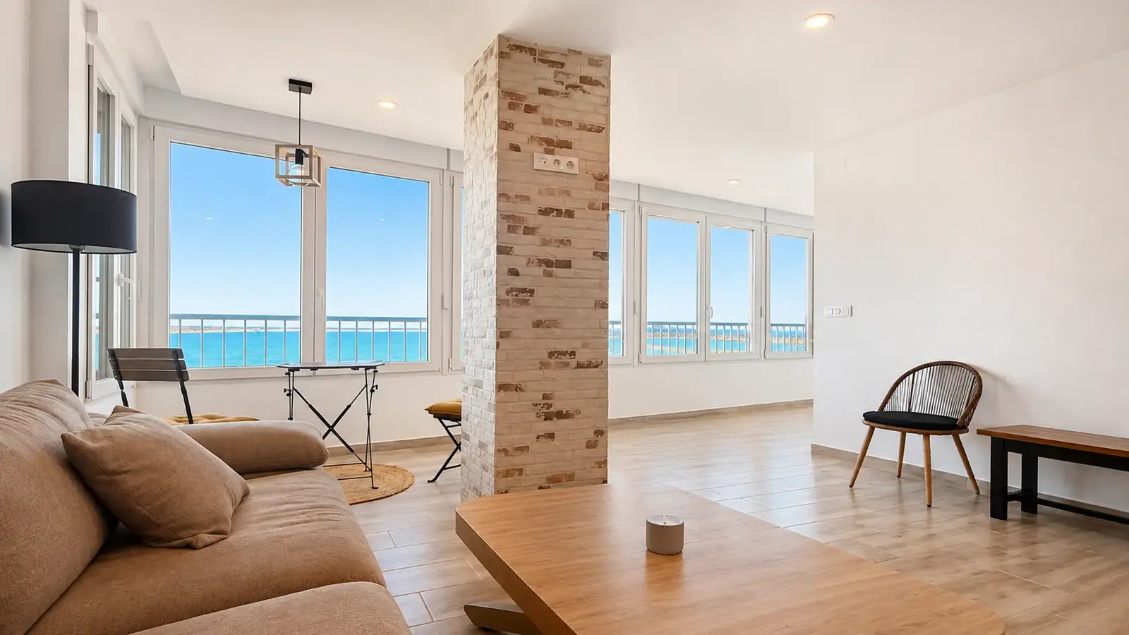 Sea-view living room at golden hour in a beachfront apartment in Torrevieja