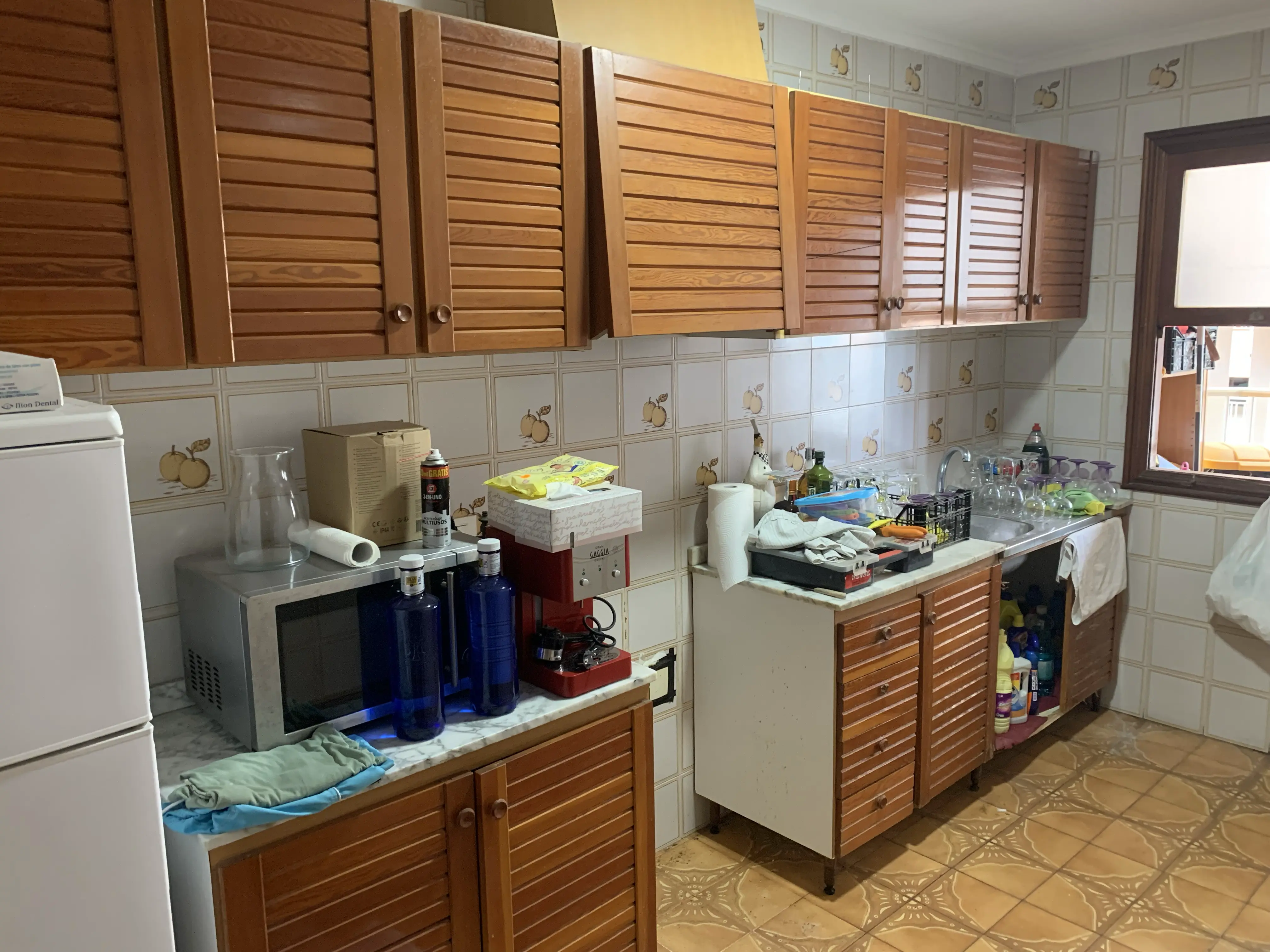 Kitchen before renovation &mdash; classic Costa Blanca flat with wooden cabinets, tiled walls and original fittings