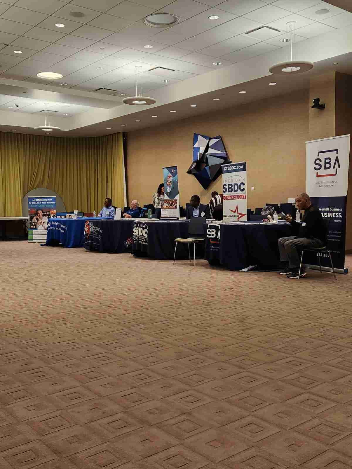 People at a business conference with SBA and SBDC banners
