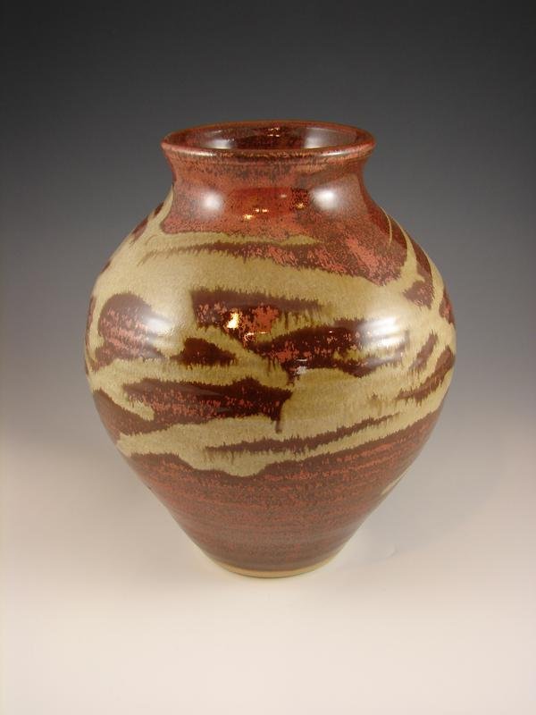 Rounded pottery vessel with cream and rust/copper colored glaze