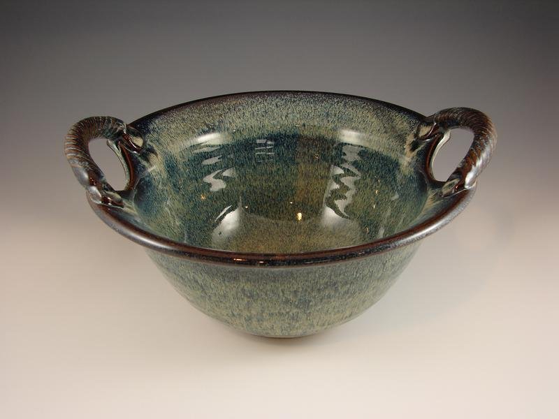 Two-handled pottery bowl with green and brown glaze tones