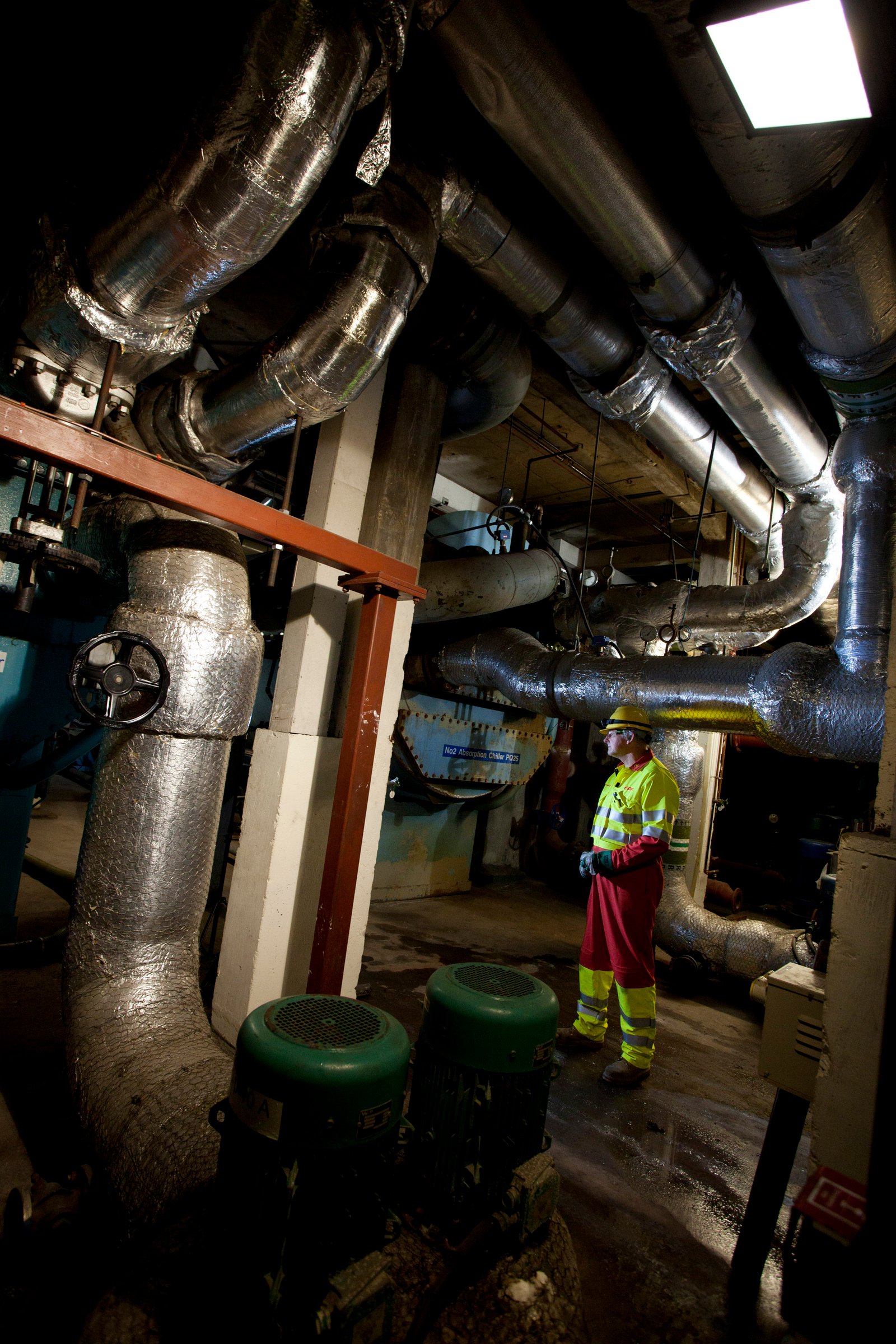 Industrial documentary photography of an engineer working among the pipes and machinery of a plant by Doug Marke.