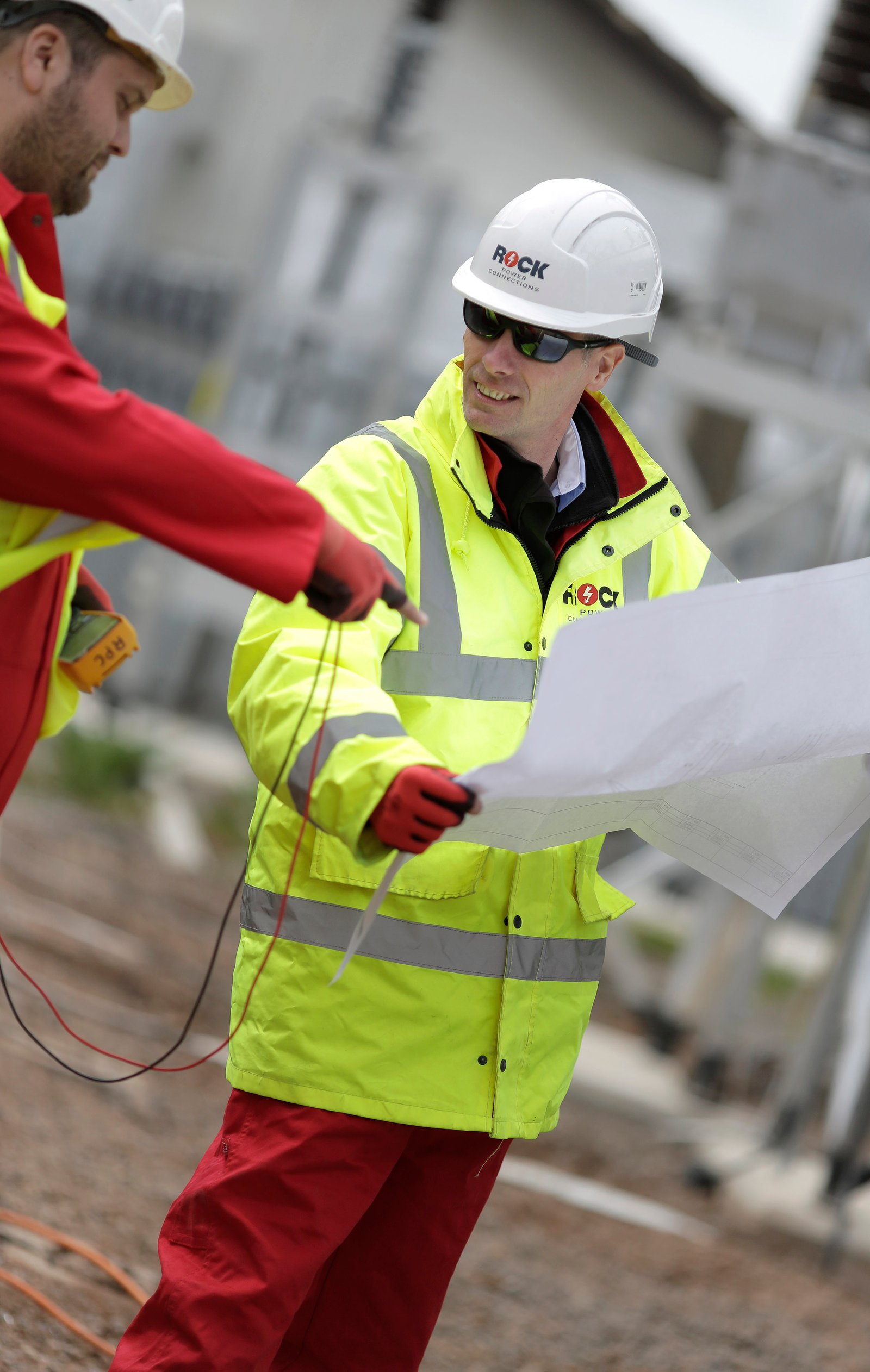Documentary photography of construction workers discussing a site plan by Doug Marke.