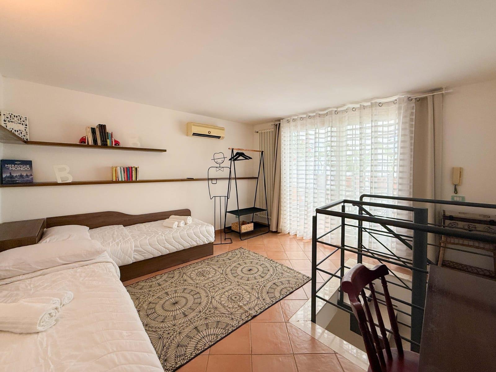 Loft with two single beds and a bookcase