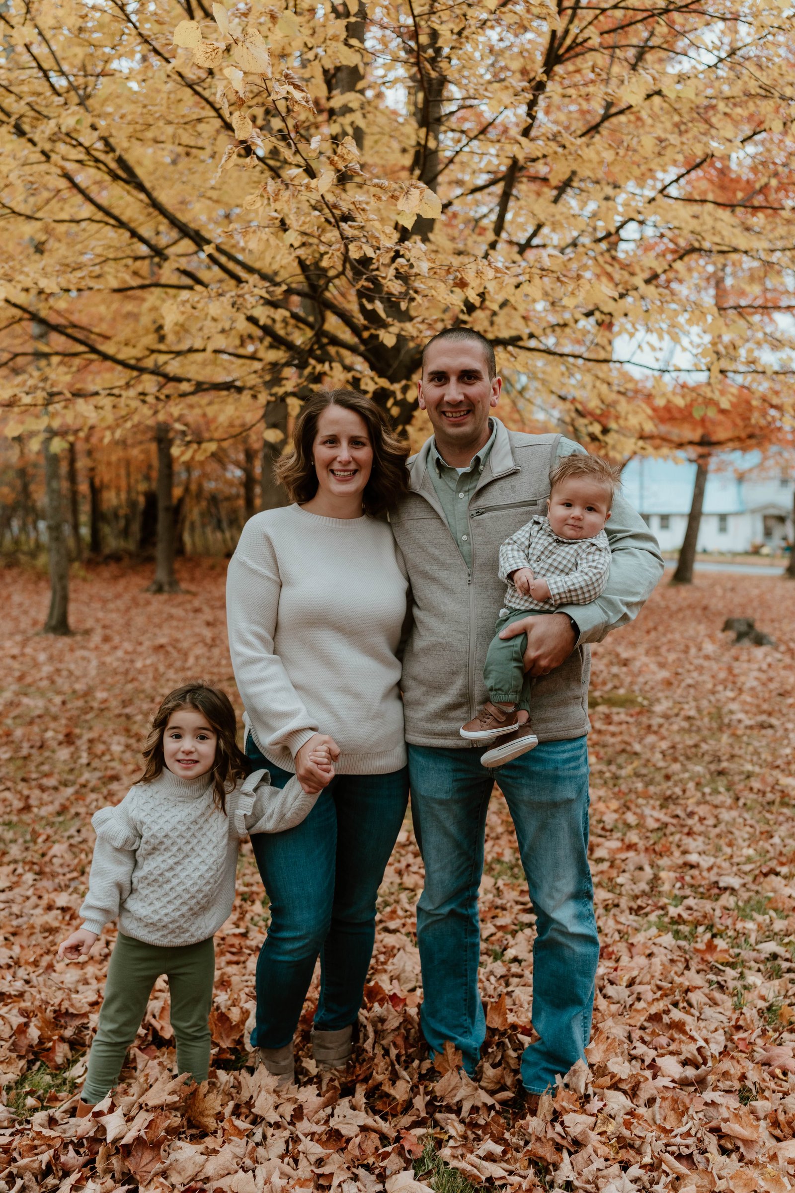 CJ and Kyla Oliver with their children in a fall forest setting
