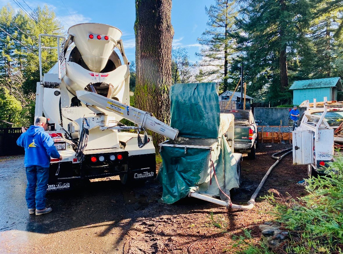 professional concrete pump truck in action at job site with operator in blue uniform